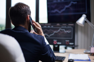 Back view of young business bearded man having a phone call with his CEO