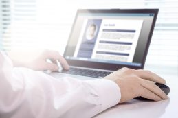 Uma pessoa usando o computador, com a tela sendo analisada enquanto ela decide melhorar o currículo antes de enviar para uma empresa