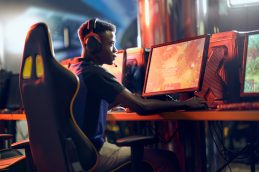 Homem em frente ao computador focado no jogo.