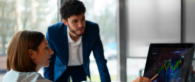 Pessoas no escritório analisando e verificando gráficos financeiros.