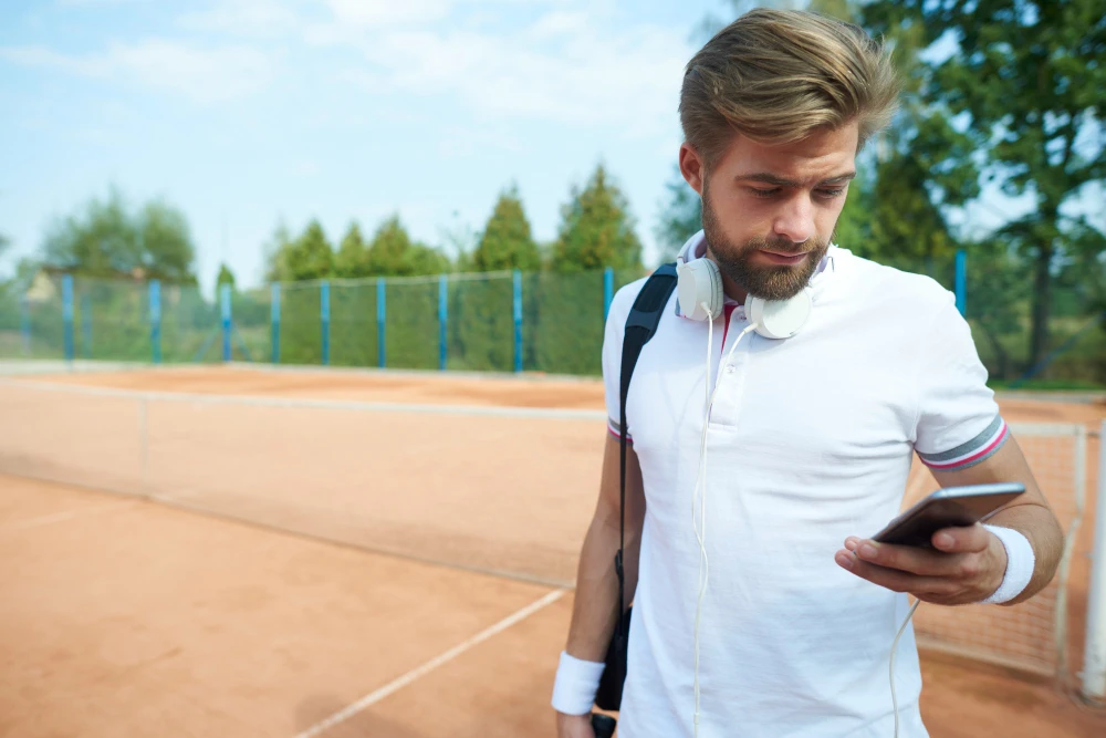 Profissional de marketing esportivo analisando métricas no celular.